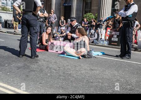 Westminster, le 26 juin 2020. Londres, Royaume-Uni. Les militants des droits des animaux se réunissent en face de la Maison canadienne à Trafalgar Square pour démontrer la mort de Regan Russell, tué à l'extérieur d'un abattoir de l'Ontario lorsqu'il a été frappé par un camion. Deux activistes se sont mis dans la rue attachée l'un à l'autre. La police intervient pour contenir les manifestants. Banque D'Images