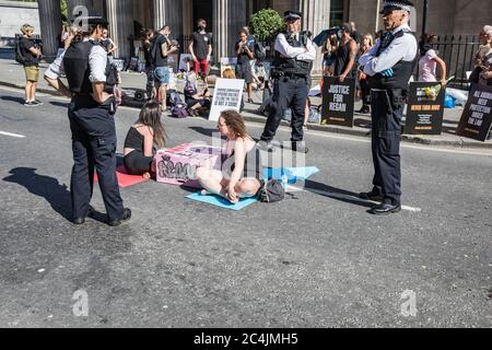 Westminster, le 26 juin 2020. Londres, Royaume-Uni. Les militants des droits des animaux se réunissent en face de la Maison canadienne à Trafalgar Square pour démontrer la mort de Regan Russell, tué à l'extérieur d'un abattoir de l'Ontario lorsqu'il a été frappé par un camion. Deux activistes se sont mis dans la rue attachée l'un à l'autre. La police intervient pour contenir les manifestants. Banque D'Images