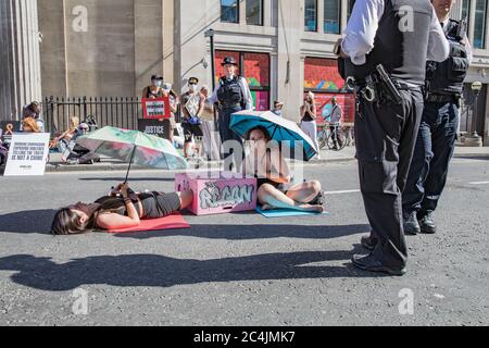 Westminster, le 26 juin 2020. Londres, Royaume-Uni. Les militants des droits des animaux se réunissent en face de la Maison canadienne à Trafalgar Square pour démontrer la mort de Regan Russell, tué à l'extérieur d'un abattoir de l'Ontario lorsqu'il a été frappé par un camion. Deux activistes se sont mis dans la rue attachée l'un à l'autre. La police intervient pour contenir les manifestants. Banque D'Images