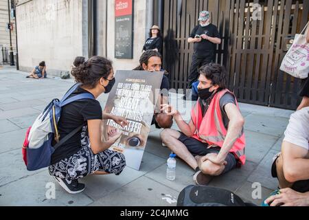 Westminster, le 26 juin 2020. Londres, Royaume-Uni. Les militants des droits des animaux se réunissent en face de la Maison canadienne à Trafalgar Square pour démontrer la mort de Regan Russell, tué à l'extérieur d'un abattoir de l'Ontario lorsqu'il a été frappé par un camion. Deux activistes se sont mis dans la rue attachée l'un à l'autre. La police intervient pour contenir les manifestants. Banque D'Images