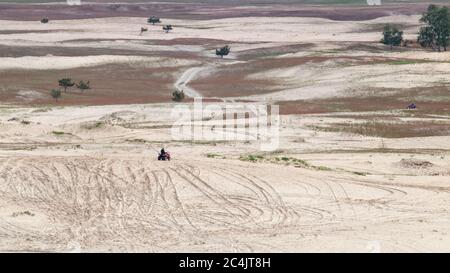 Personnes à vélo quadbike moto dans le désert de Kitsevka sables vallonnés en Ukraine, région de Kharkiv paysage. Paysages éloignés de conduite tout-terrain Banque D'Images