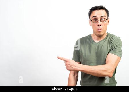 Homme choqué avec des lunettes pointant de côté. Photo intermédiaire. Fond blanc. Banque D'Images