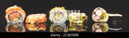 Rouleau de sushi sur fond de verre noir. Vue sur la cuisine traditionnelle japonaise asiatique Banque D'Images