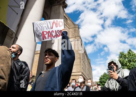 Un manifestant a tenu une pancarte disant, dire non au racisme, pendant la manifestation.les manifestants se sont rassemblés pour marquer le premier anniversaire de la mort de Shukri Abdi, âgé de 12 ans, dans un contexte d'intimidation et de manquements de la police. Il y a 12 mois que le corps de la jeune fille a été trouvé dans la rivière Irwell, Manchester et sa famille, qui est venue de la Somalie dans le Grand Manchester, attendent toujours les résultats d'une enquête sur sa mort. Banque D'Images