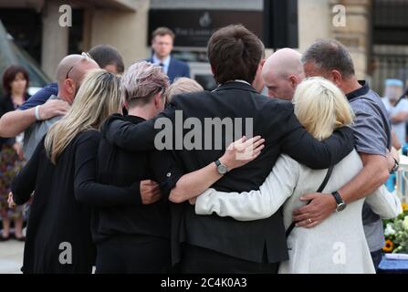 Les membres de la famille des trois victimes se réconfortent après avoir allumé des bougies lors d'une veillée à Market place, Reading, à la mémoire de David Wails, Joseph Ritchie-Bennett et James Furlong, qui ont été tués lors de l'attaque terroriste de Reading dans les jardins de Forbury, dans le centre-ville, peu avant 19h, le 20 juin. Banque D'Images