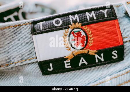 Gros plan de l'étiquette Tommy Hilfiger sur un Jean bleu. Banque D'Images