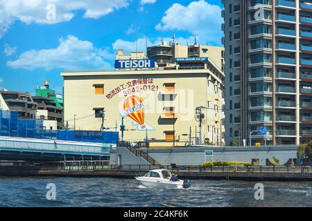 tokyo, japon - avril 04 2020 : bateau à moteur devant le pont de fer Kiyosubashi naviguant dans la rivière Sumida de Tokyo. Banque D'Images