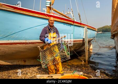 Ce panier collecteur est tiré derrière le bateau à voile et détache les huîtres sauvages de Cornouailles de leur sous-sol.James Brown, l'un des derniers pêcheurs d'huîtres de Cornwall devant son voilier Banque D'Images