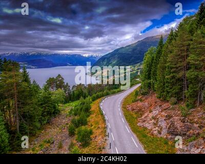 Vue aérienne de la route sinueuse le long des montagnes et du lac. Paysage de montagne à couper le souffle de la nature norvégienne Banque D'Images