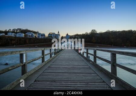 Jetée en bois de Sellin dans la soirée. Section côtière avec jetée sans éclairage avec vue sur la ville et les bâtiments. La mer Baltique en automne Banque D'Images