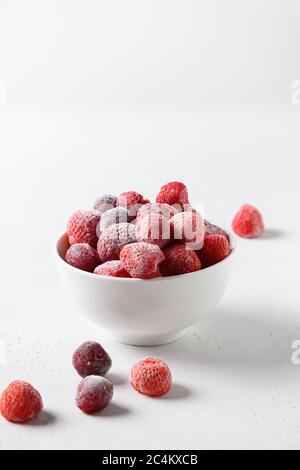 Fraises surgelées et cerises dans un bol sur fond blanc. Banque D'Images