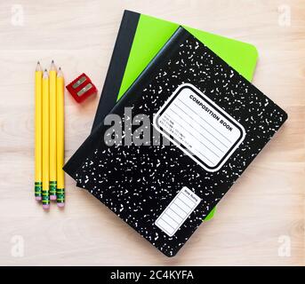 rentrée - 4 crayons jaunes, un taille-crayon rouge et deux carnets sur un bureau en bois avec espace pour les copies Banque D'Images