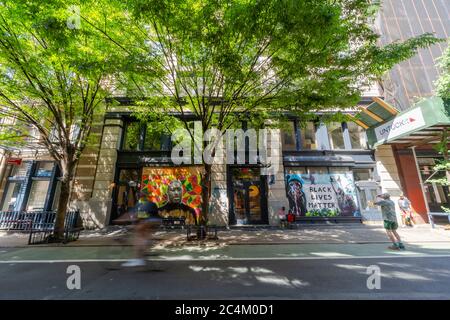 De nombreux artistes créent de la peinture murale sur le panneau de barricade des vitrines de magasins à SOHO Banque D'Images