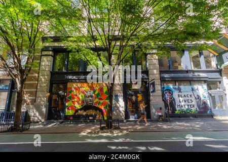 De nombreux artistes créent de la peinture murale sur le panneau de barricade des vitrines de magasins à SOHO Banque D'Images