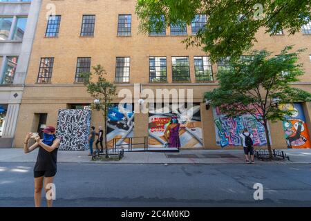 De nombreux artistes créent de la peinture murale sur le panneau de barricade des vitrines de magasins à SOHO Banque D'Images