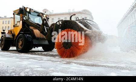 Chasse-neige véhicule de camion déneigement après le blizzard et la tempête de neige en mouvement. Nettoyage urgent de la rue à la lumière du jour. Chute de neige à la ville européenne. Winte Banque D'Images