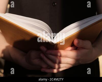 Réservez en gros plan en plein jour. La personne est en train de lire un livre intéressant Banque D'Images