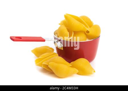 un petit pot de cuisson rouge rempli de pâtes à coque jumbo isolées sur blanc Banque D'Images