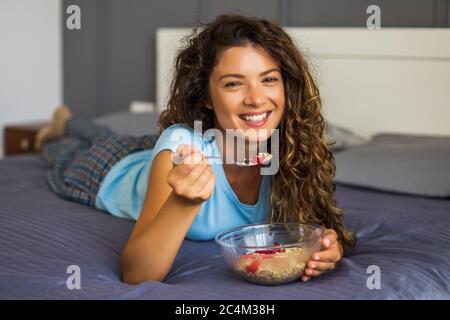 Belle femme aime manger des céréales pour le petit déjeuner. Banque D'Images