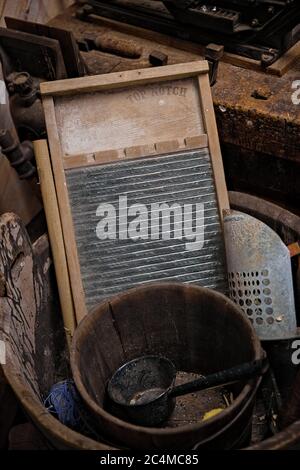 Un ancien washboard en zinc repose dans une baignoire à linge en bois. Banque D'Images