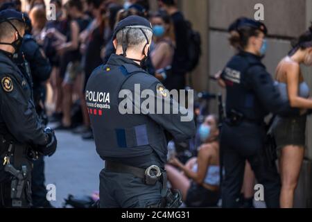 Barcelone, Espagne. 27 juin 2020. Des policiers catalans sont vus pendant l'arrestation et la fouille d'un groupe d'antifascistes.environ 150 personnes appartenant au parti d'extrême droite espagnol VOX se sont rassemblées à la base du monument de Christophe Colomb pour défendre la permanence de Colomb comme symbole de Barcelone contre l'attaque par groupes antiracistes. Crédit : SOPA Images Limited/Alamy Live News Banque D'Images