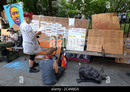 New York, NY 26 juin 2020. Les gens d'un poste d'action législative à l'hôtel de ville d'Occupy avec des panneaux indiquant comment communiquer avec les membres du Conseil de la ville de New York pour exiger qu'ils réduisent le budget de NYPD de 1 milliard de dollars. Activistes avec voix avec activistes et leaders communautaires (vocal NY) Et les alliés ont occupé un parc adjacent à l'hôtel de ville avant la date limite du 1er juillet pour exercer des pressions directes sur le maire et le conseil municipal pour qu'ils définancent le NYPD d'au moins 1 milliard de dollars de leur budget annuel de 6 milliards de dollars pour réinvestir dans le logement, les soins de santé, l'éducation et les services sociaux. Banque D'Images