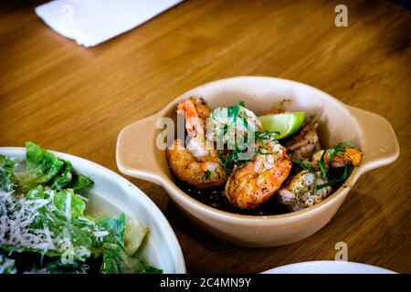 Gambas al Adillo fraîchement grillé, pinchos de crevettes au piment et à l'ail, servis sur une table en bois Banque D'Images