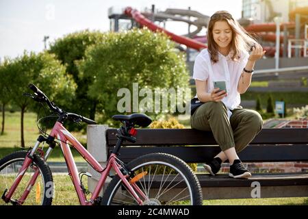 Vélo urbain adolescente avec téléphone, vélo en ville. Un style de vie actif. Banque D'Images