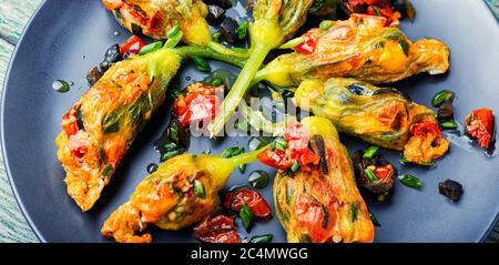 Délicieuses fleurs de courgettes frites farcies de tomates séchées.nourriture d'été. Banque D'Images