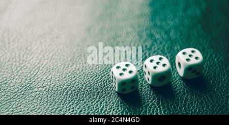 Dés avec des fives sur une table en cuir vert Banque D'Images