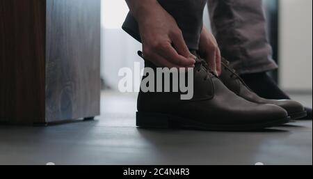 Un jeune homme a mis ses bottes Chukka en cuir marron à l'intérieur Banque D'Images