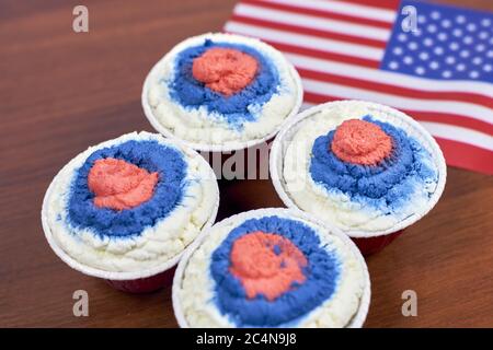 Mise au point douce de quatre desserts colorés dans une tasse en papier Avec un drapeau américain flou en arrière-plan Banque D'Images