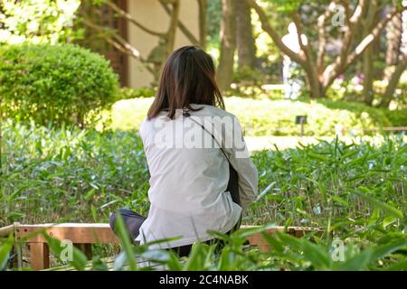 Une dame se détendant dans un parc public de Tokyo, au Japon. Banque D'Images