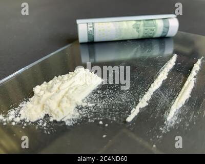 Gros plan sur un fond 100 gris de dollars américains et de 2 lignes de cocaïne. Toxicomanie illégale. Image de stock. Banque D'Images