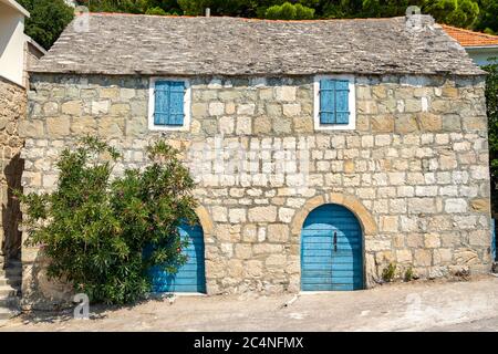 Maison traditionnelle en pierre avec porte bleue et fenêtre en Croatie Banque D'Images