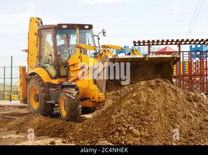 Concept du tracteur, le tracteur creuse et enterre une tranchée Banque D'Images