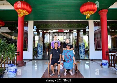 (200628) -- NANCHANG, 28 juin 2020 (Xinhua) -- Zhu Yicai (L,front) pose pour une photo avec sa famille dans sa ferme dans la région pittoresque du lac Poyang, dans le comté de Yugan, province de Jiangxi, en Chine orientale, le 16 juin 2020. Zhu Yicai a abandonné son entreprise de pêche en 2012 en raison de l'aggravation de l'environnement aquatique dans le lac Poyang. En 2018, Zhu était à la tête d'une ferme familiale quand il remarqua qu'un grand nombre de touristes venaient au lac pour observer les oiseaux migrateurs. Zhu a ensuite saisi l'opportunité commerciale et a ouvert une ferme de 1,800 m², qui peut accueillir plus de 200 personnes en même temps. Chine Banque D'Images