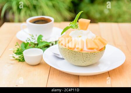 Melon Bingsu avec Lait condensé Sucré sur table en bois Banque D'Images