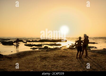 Père et fils apprécient la vue sur le coucher de soleil sur la mer de Sicile en vacances d'été Banque D'Images