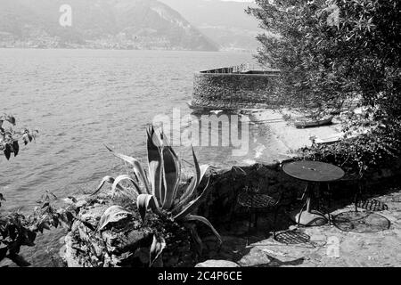 Dervio, province de Lecco, région Lombardie, rive est du lac de Côme, Italie. Le village de Corenno Plino, une vue sur le hameau, une vue panoramique sur le lac en noir et blanc. Banque D'Images