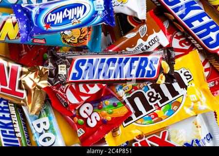 Ukraine, Kiev - 23 mars 2020 : un bouquet de barres de chocolat, dont des Snickers, Twix, Milka, KitKat, Lion, M&M, Bounty, sur fond jaune. Banque D'Images