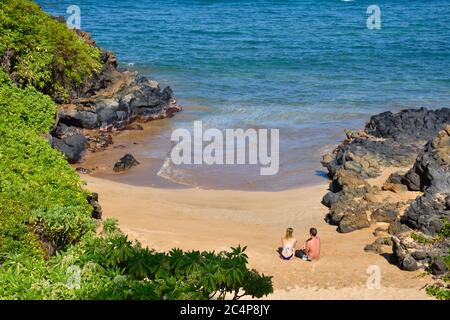 Un couple se détend dans un coin confortable de Wailea Beach, Maui, Hawaii, États-Unis Banque D'Images