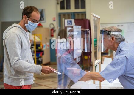 (200628) -- PARIS, le 28 juin 2020 (Xinhua) -- UN homme portant un masque de protection se prépare à voter dans un bureau de vote au cours du deuxième tour des élections municipales à Paris, en France, le 28 juin 2020. Alors que les indicateurs épidémiques de la COVID-19 continuent de s'améliorer en France, quelque 16.5 millions d'électeurs sont appelés à voter dimanche au deuxième tour des élections municipales, dans le cadre d'un protocole sanitaire strict. Le deuxième tour des élections municipales était prévu pour mars 22, mais l'aggravation des épidémies de coronavirus et le confinement des virus avaient forcé le gouvernement français à le reporter. (Photo d'Aurelie Banque D'Images