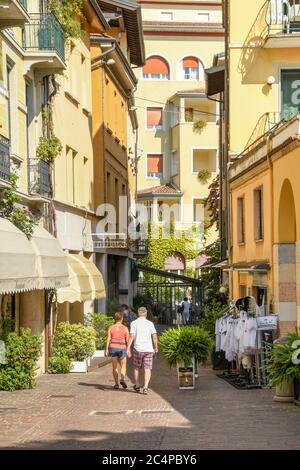 GARDONE RIVIERA, ITALIE - SEPTEMBRE 2018 : deux personnes marchant dans une rue étroite de Gardone Riviera sur le lac de Garde. Banque D'Images