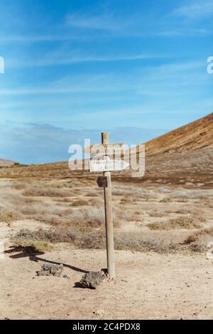 Un panneau en bois au milieu de la Graciosa, à une jonction de pistes poussiéreuses, pointant vers divers endroits, Île Graciosa, îles Canaries, Espagne Banque D'Images