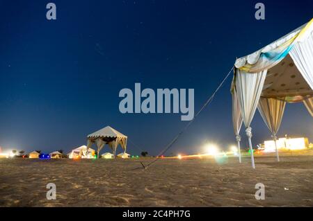 Photo nocturne du camp de désert à Sum dans le désert de Thar avec des tentes blanches pour les visiteurs et le ciel bleu au-dessus avec des étoiles brillantes Banque D'Images