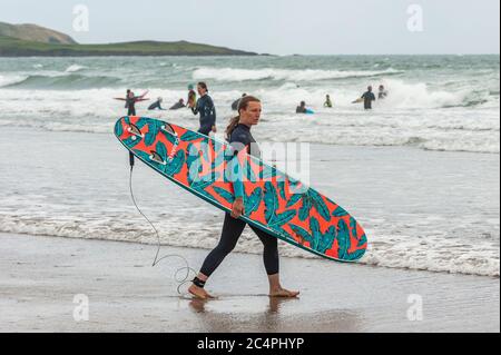 Garretstown, West Cork, Irlande. 28 juin 2020. Par une journée très venteuse à Garretstown Beach, une femme entre dans la mer pour surfer quelques vagues. Crédit : AG News/Alay Live News Banque D'Images