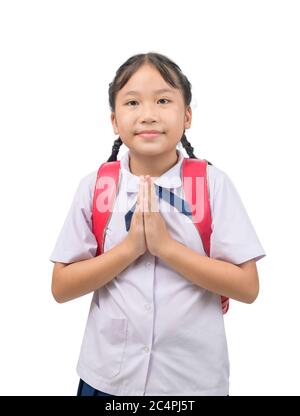 Enfant asiatique dans l'uniforme scolaire et le sac à dos avec salutation traditionnelle de la Thaïlande sur fond blanc isolé, payer le respect ou Sawasdee concept Banque D'Images