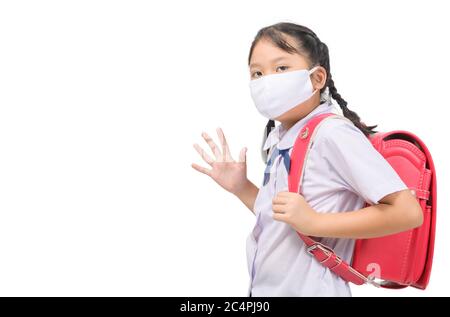 Fille asiatique étudiant porter masque et se déchèrer avant d'aller à l'école isolée sur fond blanc. Retour à l'école avec nouveau concept normal Banque D'Images
