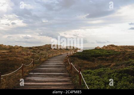 Chemin en bois menant à la plage par une journée nuageux Banque D'Images